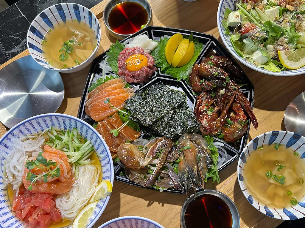 サーモンやカニ、麺料理が彩り豊かに盛られ、副菜と共に並ぶ新鮮な海鮮セットです