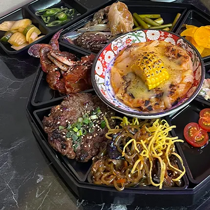 黒いプレートの上に海鮮や焼き物が色鮮やかに盛り付けられた、食欲をそそる料理です