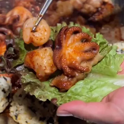 辛味の効いたタコと海鮮を葉っぱに包んだ、旨味あふれるサムギョプサルが今にも食べられそうな一枚です