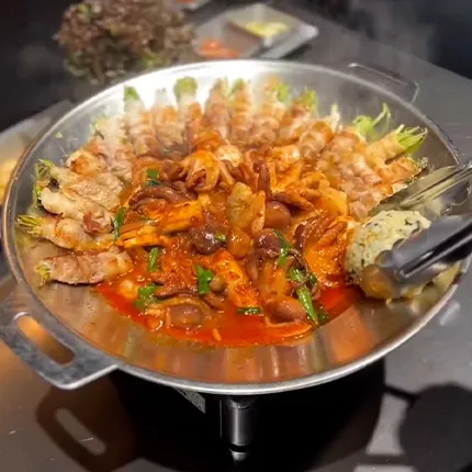 赤い濃厚なソースでタコと豚肉が熱々に煮込まれ、食卓を彩る迫力ある一品です