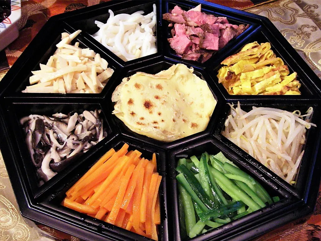 韓国料理のクジョルパンが彩り豊かな具材と薄い皮を中心に美しく並べられています